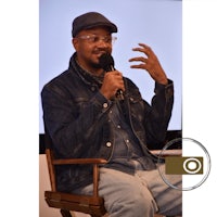 a man sitting in a chair holding a microphone