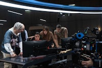 a group of people standing around a table in front of a camera