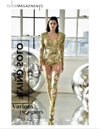 a woman in a gold outfit walks down the runway