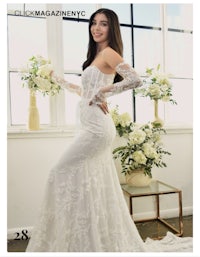 a woman in a white wedding dress is posing in front of flowers