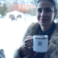 a woman in a fur coat holding a cup of coffee