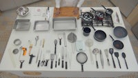 a man standing in front of a kitchen with a lot of utensils