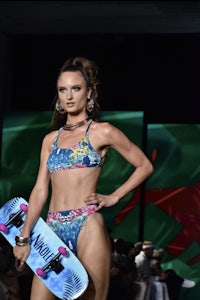 a model wearing a bikini and a skateboard on the runway