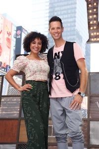 a man and woman posing for a picture in front of a building