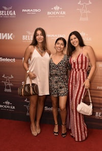 three women posing for a picture on a red carpet