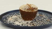 a muffin with sesame seeds on top of a plate