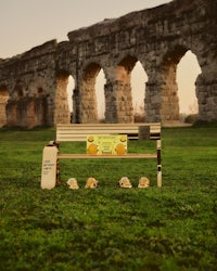 a bench in front of an aqueduct