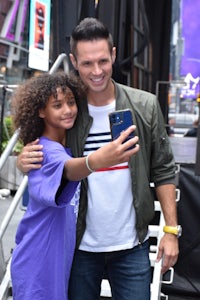 a man and a girl taking a selfie in front of a building