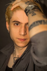 a young man with blond hair and tattoos