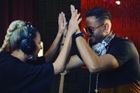 a man and woman in a recording studio giving each other high fives