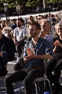 a group of people sitting in chairs and clapping