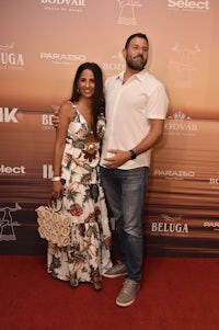 a man and woman standing on a red carpet at an event