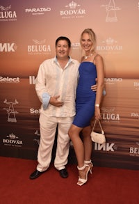 a man and woman posing on a red carpet