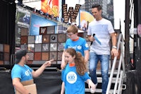 a group of people standing on a stage in times square