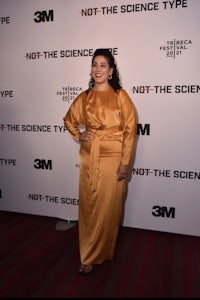 a woman in a yellow dress standing on a red carpet