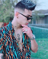 a young man wearing a zebra print shirt and sunglasses