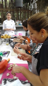 a group of women are preparing food at a table