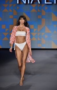 a model walks down the runway in a bikini