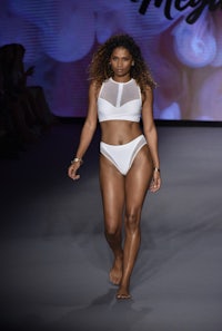 a woman wearing a white bikini on the runway