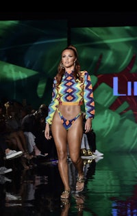 a model walks the runway in a colorful bikini