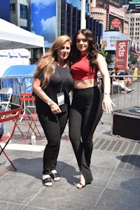 two women posing for a photo in times square