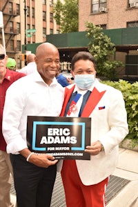 two men standing next to each other holding a sign that says eric adds