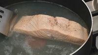 salmon fillet in a pot with a spatula