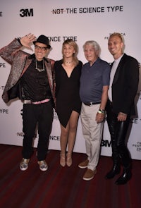 four people posing for a picture on the red carpet