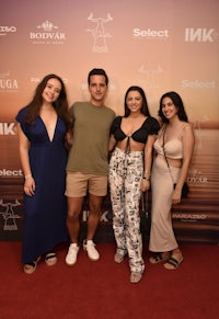 a group of people posing for a photo on a red carpet