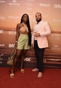 two people standing next to each other on a red carpet