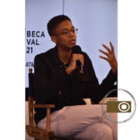 a woman sitting in a chair and speaking into a microphone