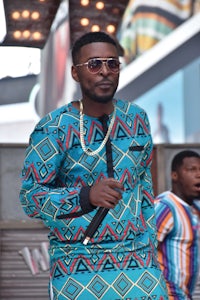 a man in an african outfit walking down the street