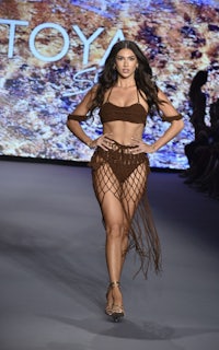 a model walks the runway in a brown bikini