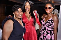 three women posing for a photo at an event