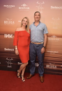 a man and woman standing on a red carpet at an event