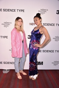 two women standing next to each other on the red carpet