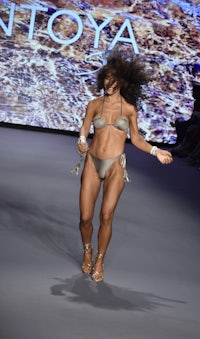 a woman in a bikini walking down the runway