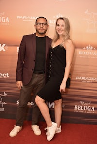 a man and woman posing on a red carpet