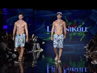 two male models walk down the runway at the linikole fashion show