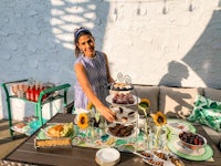 a woman standing next to a table full of desserts