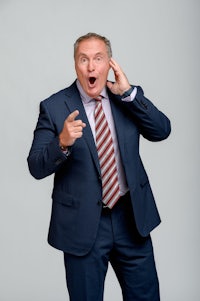 a man in a suit is talking on the phone