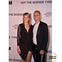 a man and woman posing for a photo on the red carpet