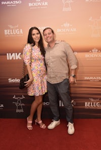 a man and woman posing on a red carpet