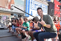 a man is posing for a picture in front of a group of people