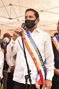 a man wearing a mask is standing in front of a microphone