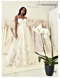 a woman in a wedding dress is standing in front of a potted orchid