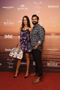 a man and woman standing on a red carpet