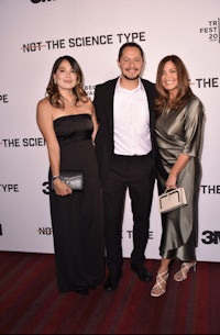 three people posing for a picture on the red carpet