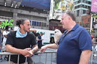 a man talking to a bird in times square