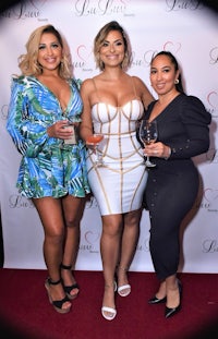 three women posing for a picture on the red carpet